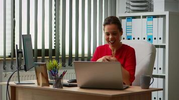 Woman talking on call using laptop sitting on office. Manager working with business remotely team discussing chatting having virtual online conference, meeting, webinar with internet technology video