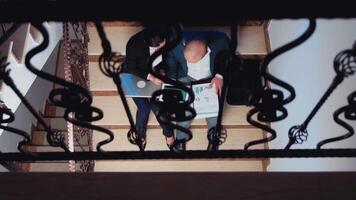 topp se av affärsmän håller på med över tid sent natt efter timmar trött på en deadline använder sig av modern grej. entreprenör arbetssätt på företags- jobb Sammanträde på trappa förklara svår finansiera projekt video