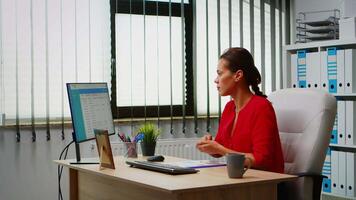 Young employee checking clipboard information looking on pc desktop. Hispanic entrepreneur working in modern professional office, workplace in personal corporate company typing on computer keyboard video