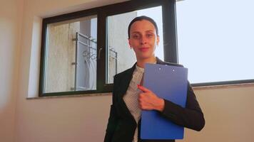 o negócio mulher sorridente desfrutando bem sucedido comece empresa, orgulhoso Gerente dentro escritório área de trabalho. empreendedor, líder posando dentro escritório em pé em escadas dentro corporativo finança prédio. video