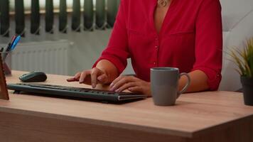 spaans vrouw typen Aan computer en op zoek Bij camera lachend. ondernemer werken in modern professioneel kantoor, werkplaats in persoonlijk zakelijke bedrijf typen Aan pc toetsenbord op zoek Bij bureaublad. video