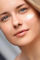 Beauty, suntan spf and skincare cosmetics model face portrait, woman with moisturising cream, sunscreen product or sun tan lotion on her cheek, luxury facial and skin care photo