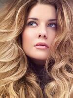hermosa moderno rubia mujer con volumen peinado, largo lujoso pelo y belleza constituir, atractivo Mira cara retrato para lujo Moda y natural productos cosméticos foto