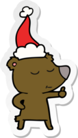 contento mano dibujado pegatina dibujos animados de un oso dando pulgares arriba vistiendo Papa Noel sombrero png