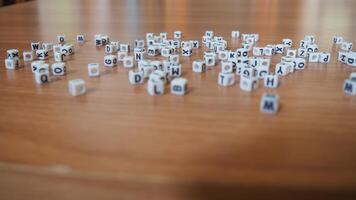 alphabet white beads blocks with letters in heart, random letters around, top view wooden background backdrop photo