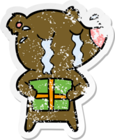 distressed sticker of a cartoon crying bear with present png