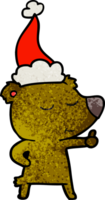 contento mano disegnato strutturato cartone animato di un' orso dando pollici su indossare Santa cappello png