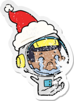hand drawn distressed sticker cartoon of a crying astronaut wearing santa hat png