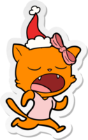 hand drawn sticker cartoon of a yawning cat wearing santa hat png