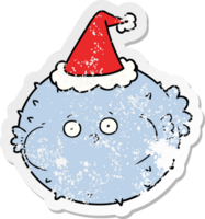 hand drawn distressed sticker cartoon of a puffer fish wearing santa hat png