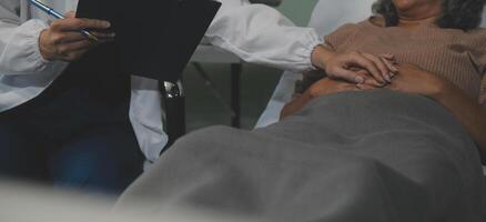 Cropped shot of a female nurse hold her senior patient's hand. Giving Support. Doctor helping old patient with Alzheimer's disease. Female carer holding hands of senior man photo