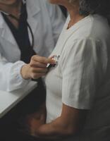 Doctor using sphygmomanometer with stethoscope checking blood pressure to a patient in the hospital. photo