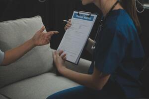 Female caregiver doing regular check-up of senior woman in her home. photo