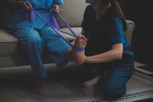 Unrecognizable senior physiotherapist working with a female patient. photo