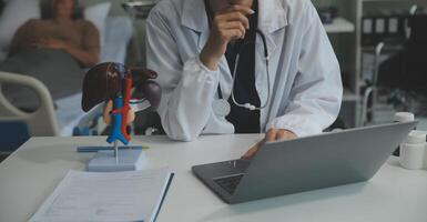 Female doctor explaining to patient results of model the process of patients. Diagnosis of diseases for Model Internal organ. photo