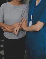 Female caregiver doing regular check-up of senior woman in her home. photo