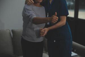 Female caregiver doing regular check-up of senior woman in her home. photo