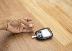 Blood drop on finger for checking blood sugar level with glucometer. photo