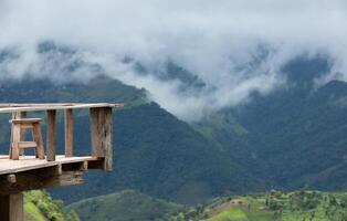 de madera terraza con el natural montaña ver con niebla en antecedentes foto