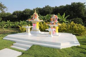 Traditional Thai spirit houses with green garden background. photo