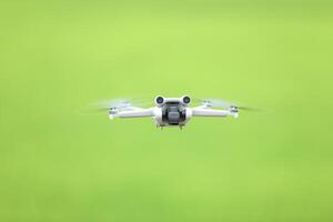 Flying drone quadcopter with a camera on green background. photo