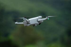 Side view of flying drone quadcopter with a camera on green background. photo