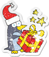 retro distressed sticker of a cartoon christmas penguin with present png