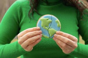 Broken cookies in the shape of the earth. Earth Day concept. Environmental problem. photo