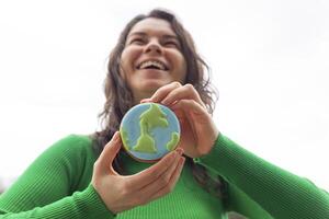 Earth Day concept. Gingerbread in the shape of a planet in the hands of a woman. photo