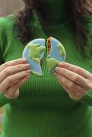 Broken cookies in the shape of the earth. Earth Day concept. Environmental problem. photo