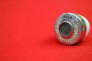 The head of the sink drain. used condition. red background photo