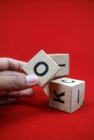 a hand holding Educational stacking cube toy made of wood with numbers and letters photo