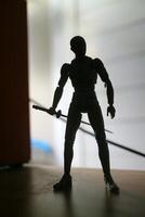 shadow silhouette of a plastic toy holding a sword photo