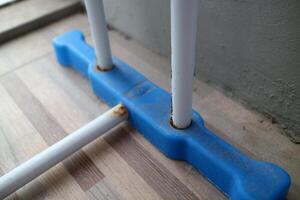 The foot of a clothesline outside the house. white and blue, made of hollow iron and plastic photo