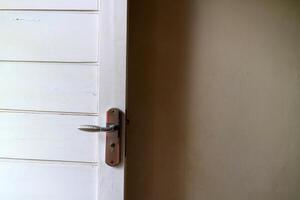 a white wooden door with white walls. with door handles made of aluminum photo