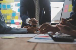 conferencia de trabajo conjunto, reunión del equipo de negocios presente, colegas inversores que discuten los datos del gráfico financiero del nuevo plan en la mesa de la oficina con computadora portátil y tableta digital, finanzas, contabilidad, inversión. foto