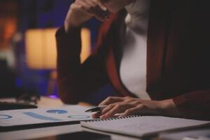 Business woman using calculator for do math finance on wooden desk in office and business working background, tax, accounting, statistics and analytic research concept photo