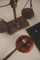 image of judge's hammer, scales lady of justice, law book, laptop computer and contract documents with pen concept of law and justice. photo