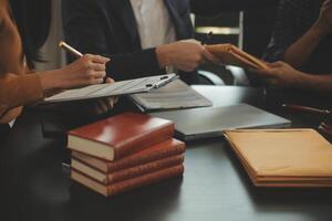 Justice and Law concept. Legal counsel presents to the client a signed contract with gavel and legal law or legal having team meeting at law firm in background photo