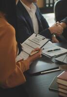 Justice and Law concept. Legal counsel presents to the client a signed contract with gavel and legal law or legal having team meeting at law firm in background photo