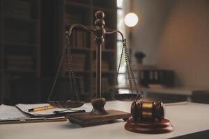 image of judge's hammer, scales lady of justice, law book, laptop computer and contract documents with pen concept of law and justice. photo