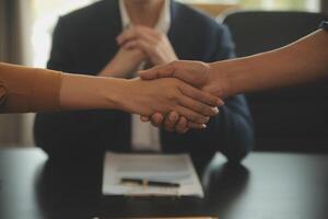 concepto de justicia y derecho. El asesor legal presenta al cliente un contrato firmado con mazo y derecho legal o una reunión de equipo legal en el bufete de abogados en segundo plano. foto