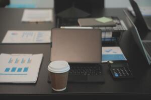 Laptop on a desk in an open financial office. photo