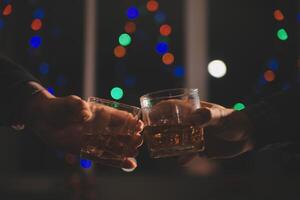 Celebration night, pour whiskey into a glass. Give to friends who come to celebrate photo