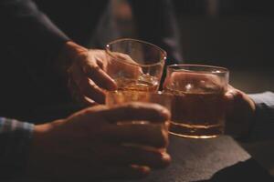 Celebration night, pour whiskey into a glass. Give to friends who come to celebrate photo