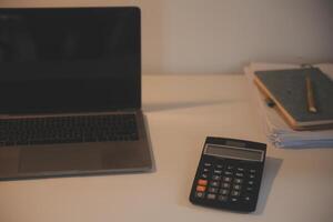 Laptop and paperwork on conference table photo