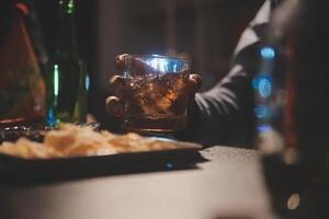 Celebration night, pour whiskey into a glass. Give to friends who come to celebrate photo