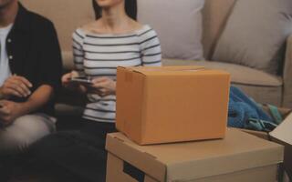 Two Asian blogger showing clothes in front of the camera to recording vlog live streaming at her shop. Online Shopping Cart notion. on sofa at home photo