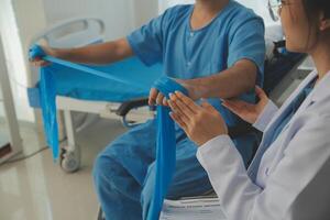 Physical therapist guiding patient with resistance band photo