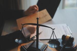 Business and lawyers discussing contract papers with brass scale on desk in office. Law, legal services, advice, justice and law concept picture with film grain effect photo